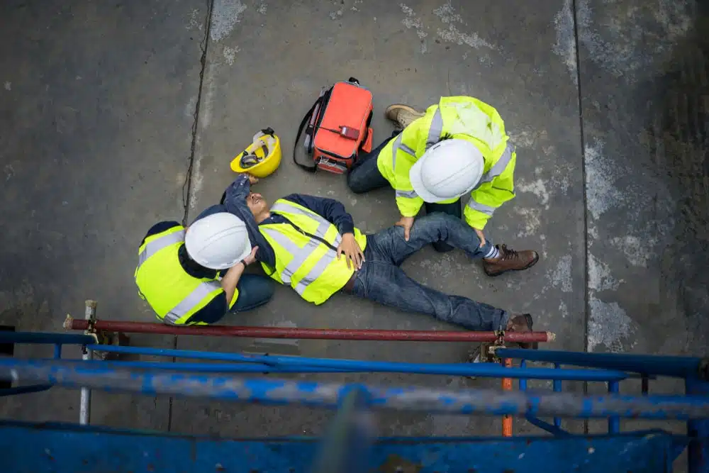 Two Men Helping Another Man Who Has Fallen From Scaffolds
